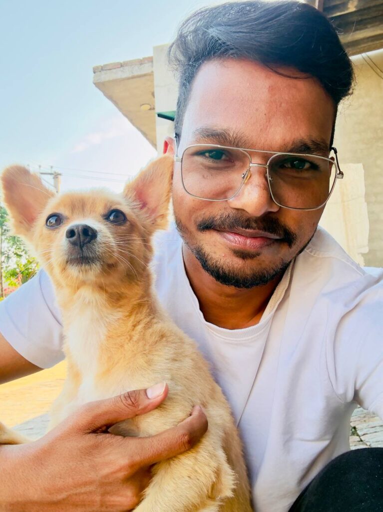 A confident young Indian male trader sitting in a modern workspace with multiple monitors showing stock charts, candlestick graphs, and trading dashboards, cinematic lighting, dark theme setup, minimal background, professional vibe, focused expression, high detail, ultra realistic, 16:9 aspect ratio, no text